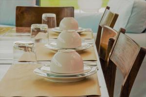a table with plates and cups on top of it at Herdade do Ananás in Ponta Delgada