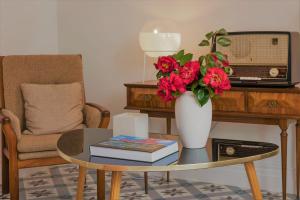 a living room with a table with a vase with flowers at Herdade do Ananás in Ponta Delgada