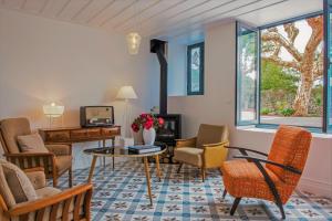 a living room with chairs and a table at Herdade do Ananás in Ponta Delgada