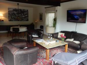 a living room with leather furniture and a coffee table at Düsseldorfer Privatzimmer in Düsseldorf