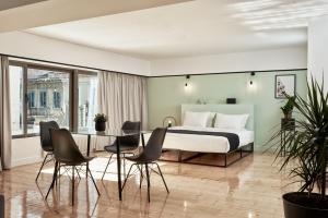1 dormitorio con 1 cama, mesa y sillas en MONO Lofts, en Atenas