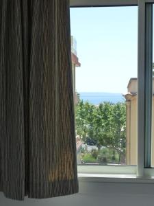 a window with a view of the ocean at Hôtel L'Oustaou in Le Lavandou