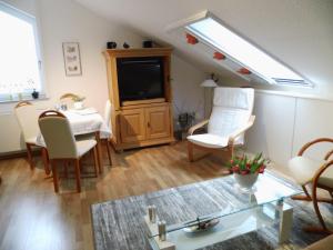 - un salon avec une télévision, une table et des chaises dans l'établissement Ferienwohnung und -Zimmer Becks, à Lüdinghausen