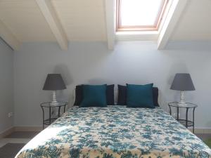 a bedroom with a bed with blue pillows and a window at Room73 in Paestum