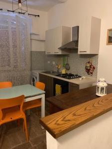 a kitchen with white cabinets and a table and chairs at Il Sementone in Assisi