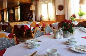 ein Esszimmer mit Tischen und Stühlen mit Blumen in der Unterkunft Gasthaus zum Rebstock in Kressbronn am Bodensee