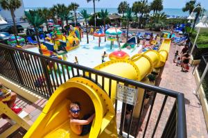 a boy is riding a slide at a water park at Sea Crest Oceanfront Resort in Myrtle Beach