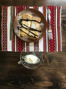 un plato de pastel con crema batida en una mesa en Villa Galicia, en Beregovo