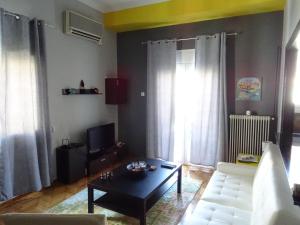 ein Wohnzimmer mit einem weißen Sofa und einem Couchtisch in der Unterkunft DP ZOGRAFOU APPARTMENT in Athen