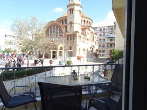 einen Tisch und Stühle auf einem Balkon mit einem Gebäude in der Unterkunft DP ZOGRAFOU APPARTMENT in Athen