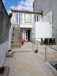 Casa blanca con escaleras, mesa y sillas en Casa Ventuzelo, en Oporto