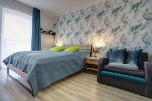 a bedroom with a bed and a couch at Apartamenty Świnoujście - Wyspiańskiego 34e in Świnoujście