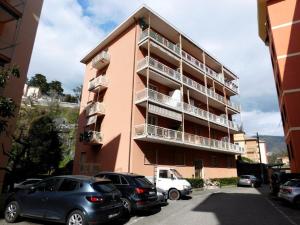 a pink building with cars parked in front of it at Fantastico appartamento in centro, Levanto in Levanto