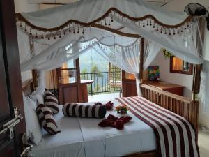 a bedroom with a white bed with a canopy at Lucky Star Ella in Ella