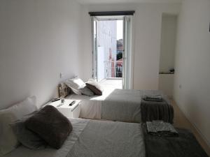 2 camas en una habitación pequeña con ventana en Casa Ventuzelo, en Oporto