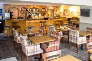 ein Restaurant mit Tischen und Stühlen und eine Bar in der Unterkunft Kyle Hotel ‘A Bespoke Hotel’ in Kyle of Lochalsh