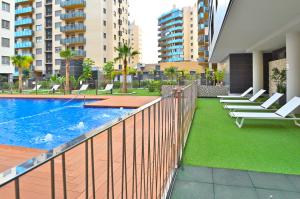 a balcony with chairs and a swimming pool in a building at MyFlats Abedules in El Campello