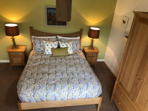 a bedroom with a bed with two lamps on both sides at Harris White Cottage in Rodel