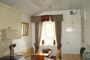 a kitchen with a dining table and a window at Harris White Cottage in Rodel