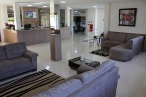 a living room with couches and a table in a lobby at Terra do Chimarrão Hotel in Venâncio Aires