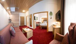 un soggiorno con divano e una camera da letto di Das Waldhotel - Genuss & Wellness am Notschreipass a Todtnau