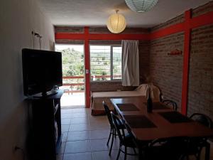 a living room with a dining room table and a television at Terrazas de mayu in Villa Icho Cruz