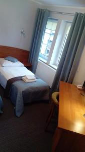 Un pat sau paturi într-o cameră la Hotel Sukiennice