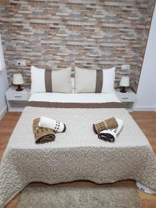 een slaapkamer met een groot bed met twee hoeden erop bij Piso Turistico/Vacacional LM in Ronda