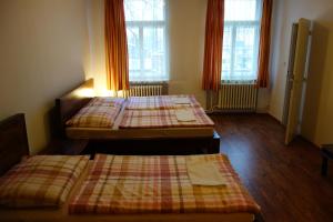 3 camas en una habitación con ventanas en Penzion - U staré pekárny, en Bohumín