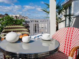 a table with two chairs and a tea set on a balcony at Hotel Eiffel Blomet in Paris