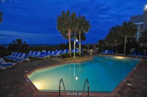 a swimming pool at night with blue lounge chairs at Sea Crest Oceanfront Resort in Myrtle Beach