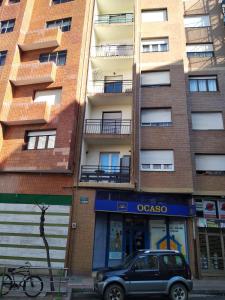 een SUV geparkeerd voor een appartementencomplex bij Habitaciones en Ronda in Castro-Urdiales