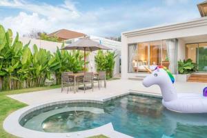 una casa con una piscina con un unicornio en el patio en Trichada Tropical, en Bang Tao Beach