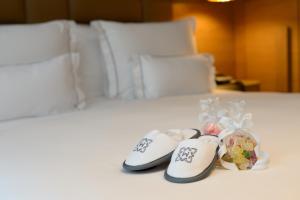 un par de zapatillas sentadas encima de una cama en Monument Hotel, en Barcelona