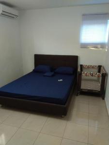 a bedroom with a bed with a blue mattress at Yolo Apartment in Willemstad