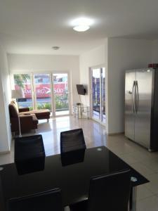een woonkamer met een tafel en een koelkast bij Yolo Apartment in Willemstad