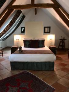 um quarto com uma cama grande no sótão em Le Puits D'Angle em Thibivillers