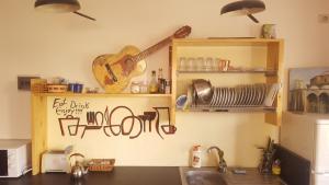 uma cozinha com uma guitarra pendurada na parede em The Rooftop Hostel em Shkodër
