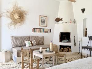 a living room with a couch and a fireplace at Dar Alya Essaouira Maison et table d'hôtes in Ghazoua