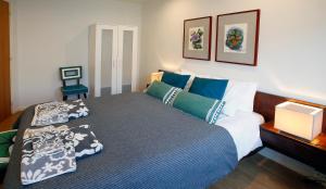 um quarto com uma cama com almofadas azuis e verdes em Anjos 44 Lisbon Apartments em Lisboa