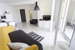 Una sala de estar con un sofá y un televisor. en Villa Franka, en Brela