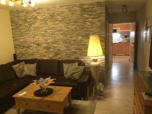 a living room with a couch and a brick wall at Seevilla West am Großen Plöner See in Ascheberg