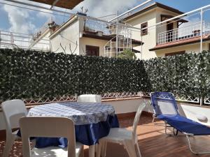 a table and chairs on a balcony with a hedge at Casa BabbaLuciana in Mondello