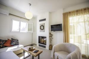 un salon avec un canapé et une chaise dans l'établissement Miltiadis Apartments Spiti Miltiadis, à Agios Georgios Pagon