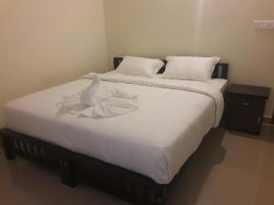 a white swan sitting on top of a bed at White Petals -3 BHK Homestay Munnar - Available For Indian Nationals Only in Munnar