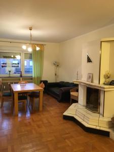 ein Wohnzimmer mit einem Tisch und einem Kamin in der Unterkunft Apartment am Friedrich Ebert Park mit über 100qm Wohnfläche in Hamm