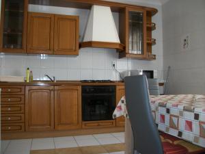 uma cozinha com armários de madeira e um forno com placa de fogão em Füge Vendégház em Miskolctapolca