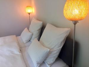 a bed with white pillows next to a lamp at Ferienwohnung Börner ll in Kniebis