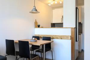 Il comprend une cuisine et une salle à manger avec une table et des chaises en bois. dans l'établissement Apartment Chamois Blanc 7A, à Chamonix-Mont-Blanc