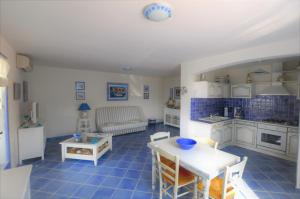 ティシアにあるRésidence U MELU Grand T2 BLEU en rez de jardinのテーブルと椅子のあるキッチンとリビングルーム